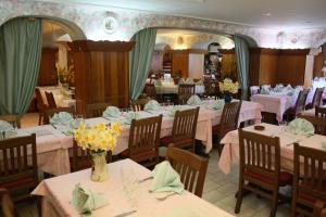 a dining room with tables and chairs with flowers on them at Bon-Séjour in Thollon