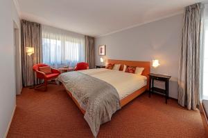 une chambre d'hôtel avec un lit, une table et des chaises dans l'établissement Wittlers Hotel, à Ratzebourg