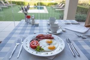 a plate of eggs and bacon on a table at La Cabriere Country House in Franschhoek