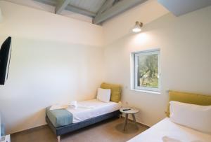 モライティカにあるThree Stars Luxury Villasのベッド2台と窓が備わる客室です。