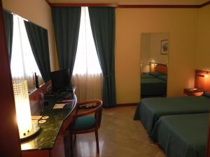 a hotel room with a bed and a desk with a computer at Hotel Vecchio Mulino in Monopoli