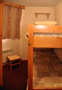 a bedroom with two bunk beds and a table at Les Melezets 1 in Valfréjus
