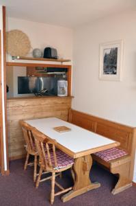 a table and chairs in a kitchen with a table and a counter at Les Melezets 1 in Valfréjus