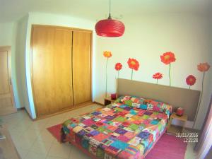 um quarto com uma cama com flores na parede em Excelente T1 Oura Beach Bicos Apartment Lucia em Albufeira