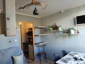 a room with a dining table and a kitchen at La Petite Ourse SUPERDEVOLUY in Le Dévoluy