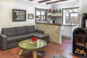 a living room with a couch and a table and a kitchen at Négy Évszak Vendégház in Noszvaj