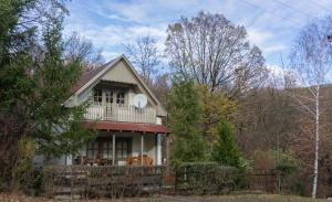 a house with a porch and a balcony at Négy Évszak Vendégház in Noszvaj