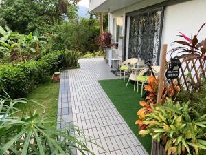 a garden path with a table and chairs and plants at City Oasis Guesthouse in Hong Kong