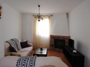 アルダレスにあるCasita Ardalesのリビングルーム(ベッド1台、暖炉付)