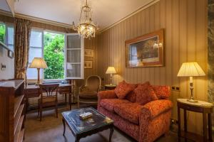 a living room with a couch and a table at Hôtel Duc De St-Simon in Paris