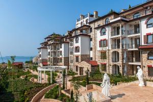 a group of buildings with statues in front of them at Artur VIP Residence Club in Sveti Vlas