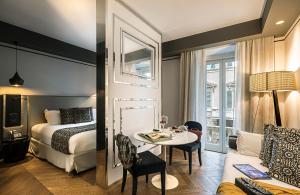 una camera d'albergo con letto e tavolo e una camera di Corso 281 Luxury Suites a Roma