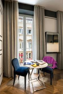 羅馬的住宿－科索281豪華套房酒店，客厅配有桌椅和窗户。