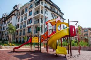 a playground with a slide in front of a building at Artur VIP Residence Club in Sveti Vlas