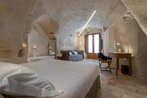 a bedroom with a large white bed and a bathroom at Conche Luxury Retreat in Matera +38 photos