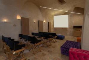 a room with a bunch of chairs and a white screen at Conche Luxury Retreat in Matera