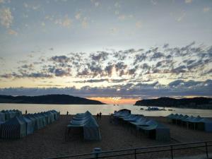 サン・マルティーニョ・ド・ポルトにあるApartamento a 4min da praia com lareiraの夕日のビーチの青い傘