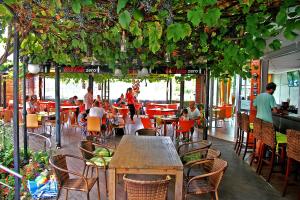un restaurante con gente sentada en mesas y sillas en Favorit Aparthotel, en Sunny Beach