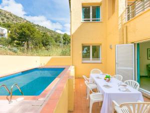a patio with a table and a swimming pool at Apartment Velazquez-9 by Interhome in Roses