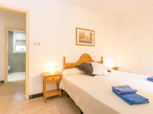 a bedroom with a large bed with a night stand and a mirror at Apartment Velazquez-9 by Interhome in Roses