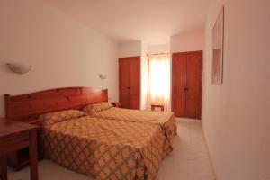 a bedroom with a bed and a table and a window at Fuerteventura Beach Club in Caleta De Fuste