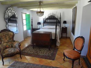 a bedroom with a bed and two chairs in it at Riola San Gabriel in Alcolecha