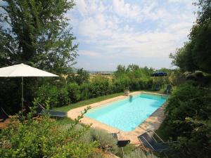 uma piscina com cadeiras e um guarda-sol em Apartment Borgo Monticelli-19 by Interhome em Castiglione della Valle