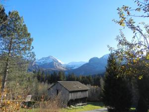 an old barn in a field with mountains in the background at Apartment Minnehaha- Chalet by Interhome in Lauenen