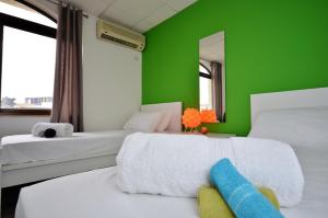a green room with two beds and a green wall at City Living Suites TK2 Rm 2 in St. Julianʼs