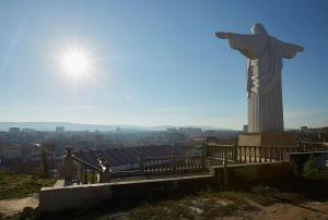 uma estátua de Cristo o redentor no topo de uma colina em Villa Bozena em Truskavets