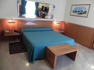 a bedroom with a blue bed and a table at Hotel Vecchio Mulino in Monopoli
