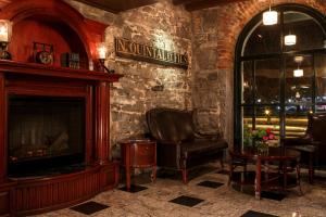 a living room with a fireplace and a chair at Auberge du Vieux Port by Gray Collection in Montreal