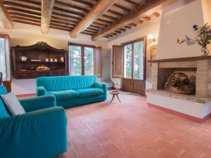 uma sala de estar com sofás azuis e uma lareira em Apartment Borgo Monticelli-19 by Interhome em Castiglione della Valle