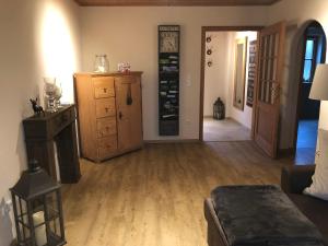 una sala de estar con suelo de madera y una habitación con puerta en Chiemsee Beachhouse Apartment, en Bernau am Chiemsee
