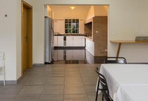 a kitchen with white cabinets and a table in a room at A Casa do Lagar in São Jorge