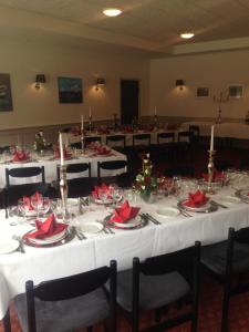 una stanza con tavoli bianchi con tovaglioli rossi sopra di Hotel Rødding a Rødding
