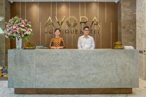 Ein Mann und eine Frau stehen hinter einem Tresen in der Unterkunft AVORA Boutique Hotel in Đà Nẵng