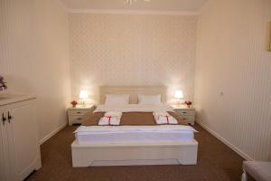 um quarto com uma grande cama branca com duas mesas de cabeceira em Royal Apartment in old Tbilisi em Tbilisi