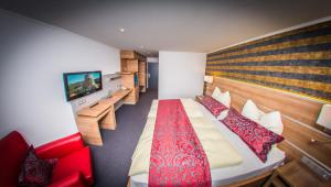 a hotel room with a large bed with a red blanket at Hotel Hellers Krug in Holzminden