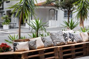 a wooden bench with many pillows on it at Hotel Heritage in Sao Paulo