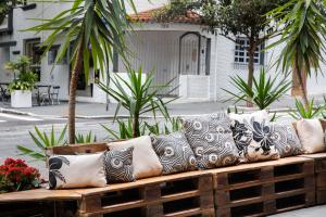 a wooden bench with many pillows on it at Hotel Heritage in São Paulo