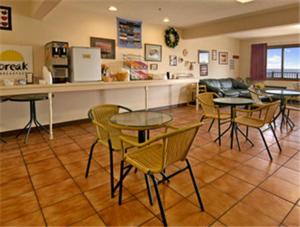 un restaurante con mesas, sillas y una barra en Bavarian Haus Lakefront Inn, en Saint Ignace