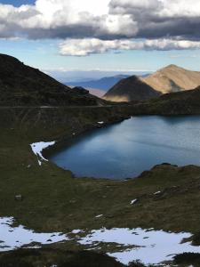 un lago en medio de un campo con montañas en Hostellerie de La Poste en Oust