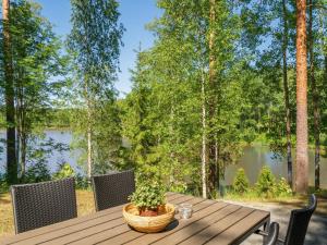 a wooden table with a potted plant sitting on it at Holiday Home Satakieli by Interhome in Hirsjärvi