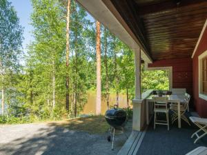 a screened in porch of a house with a grill at Holiday Home Satakieli by Interhome in Hirsjärvi