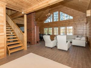 a living room with a staircase and white chairs at Holiday Home Telkkä by Interhome in Vähäsalmi