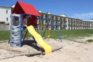 a playground in front of a building with a slide at Bavarian Haus Lakefront Inn in Saint Ignace