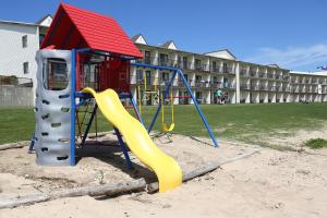 un parque infantil frente a un edificio con tobogán en Bavarian Haus Lakefront Inn, en Saint Ignace