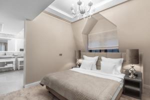 a bedroom with a large bed with a chandelier at Grand Park Hotel in Szczecin