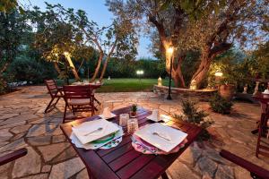 a wooden table with plates and napkins on a patio at Villa Ble in Skopelos Town